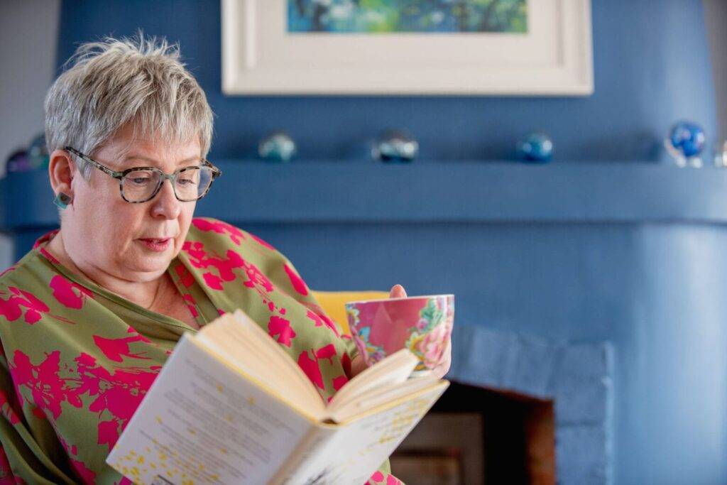 Dr Carol Sargent reading a book by Wendy Mitchell