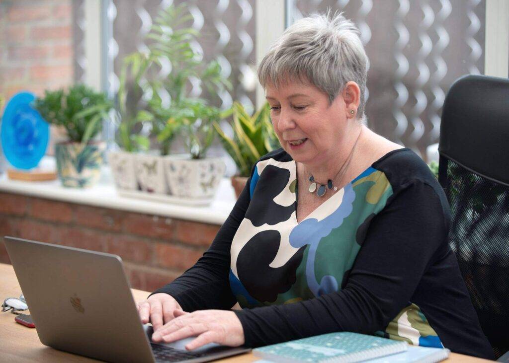 Dr Carol Sargent working on a laptop